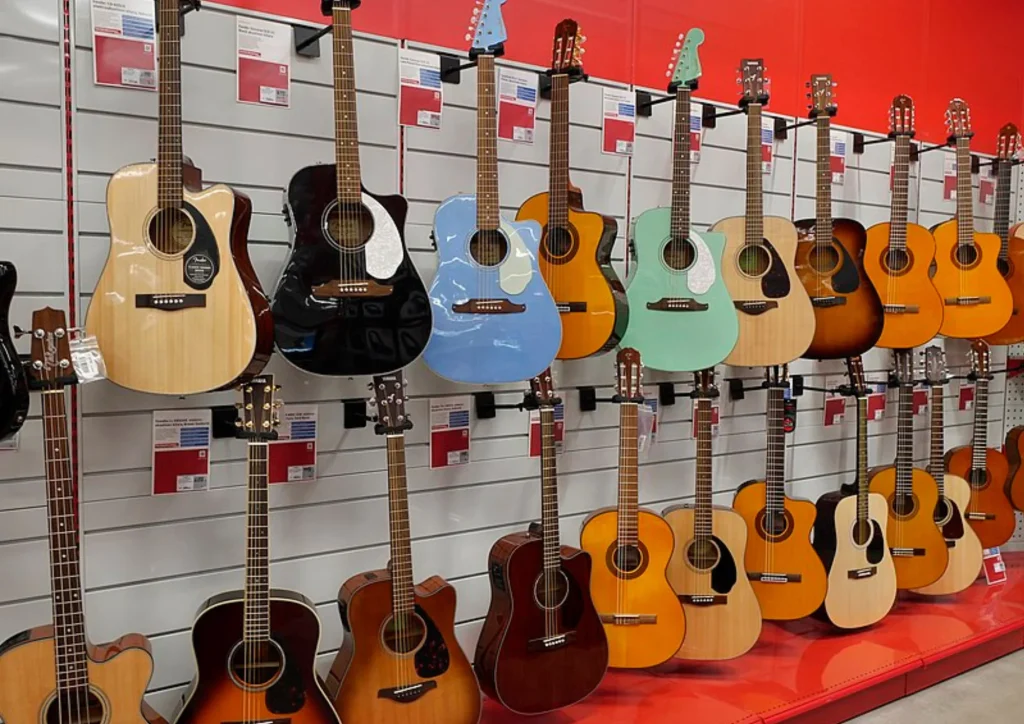 Guitarras acústicas y eléctricas colgadas en la pared de una tienda