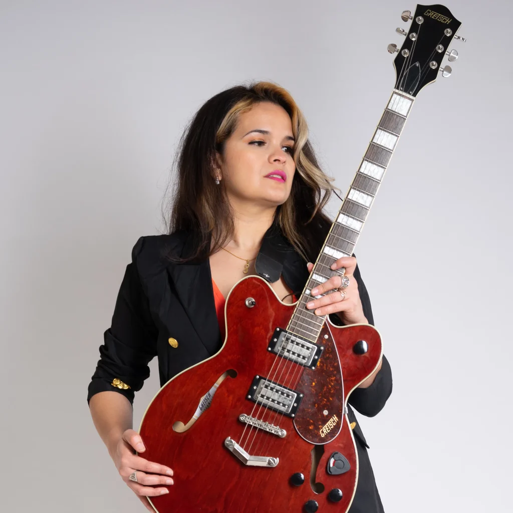La profe Yodira con una guitarra eléctrica roja